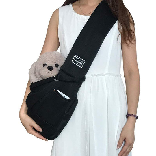 Saco para transporte de animais de estimação, cor preta, com um bicho de peluche dentro, suporte tipo bandoleira.