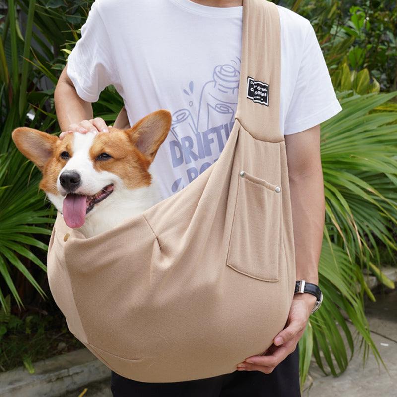 Bolsa de transporte para animais de estimação em tom bege, carregando um cão corgi, apresentando um design ergonómico e confortável.