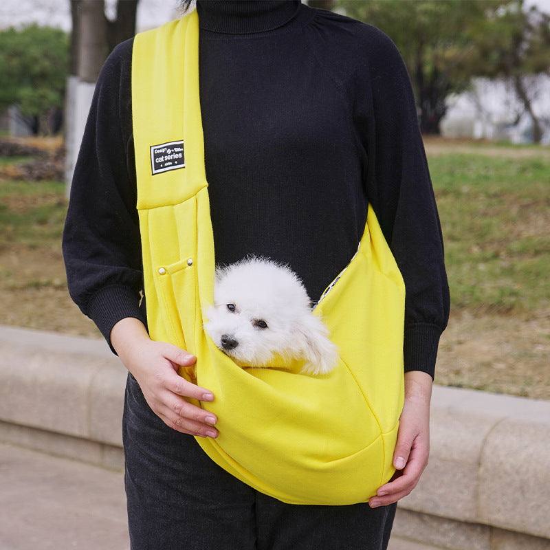 Bolsa de ombro para pets amarelo, com um pequeno cão branco acomodado na bolsa, modelo confortável e prático.