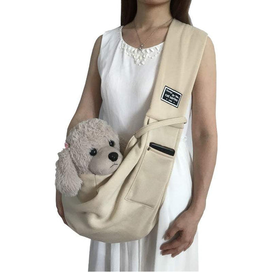 Bolsa de ombro para animais de estimação na cor bege, com um peluche dentro e bolso para telefone.