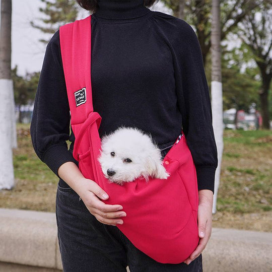 Bolsa de transporte para animais de estimação, cor rosa, com um cachorro pequeno à vista, confortável e prática para uso em passeios.