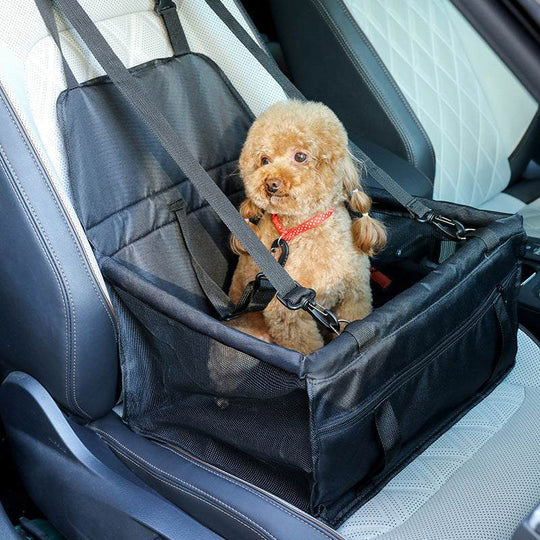 Cocheira portátil para cães, fabricada em tecido Oxford, com um cão pequeno a usar o cinto de segurança no banco do carro.