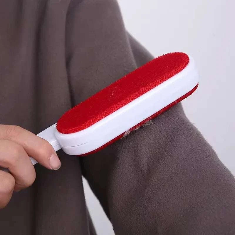 Rolo de cabelo de animal de estimação em vermelho e branco, sendo usado para remover pelos de um casaco cinza.